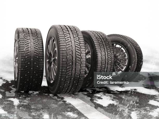 Four Car Tires Rolling On A Snowcovered Road Stock Photo - Download Image Now - Tire - Vehicle Part, Winter, Snow