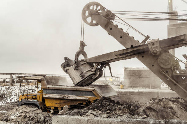 istock Bucket excavator loads into a large mining dump truck. Heavy industry. 843030282