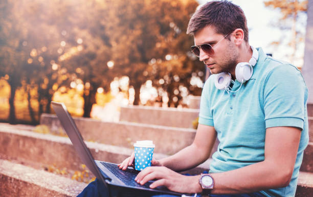 istock Young man working on a laptop in the park. Lifestyle, technology 843033366