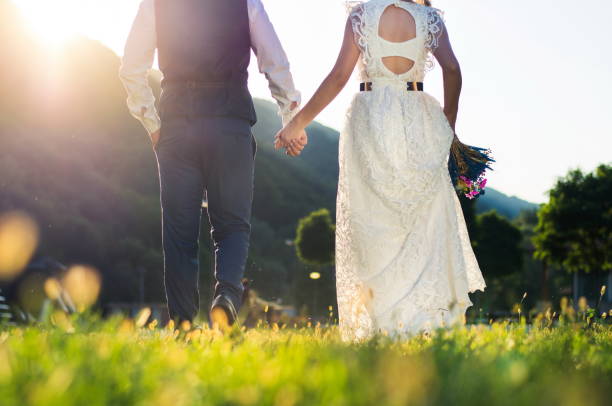 istock Bride and groom walking towards sunset holding hands 843041780