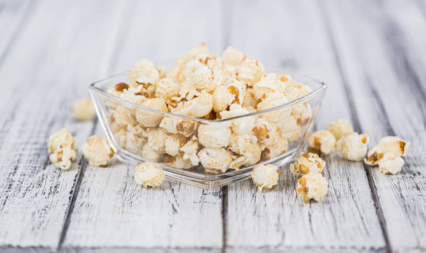 istock Portion of Popcorn on wooden background, selective focus 843042098