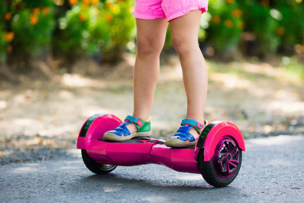 Child on hover board. Kids ride scooter. Child on hover board. Kids riding scooter in summer park. Balance board for children. Electric self balancing scooter on city street. Girl learning to ride hoverboard. Modern gadgets for school kid. hoverboard stock pictures, royalty-free photos & images