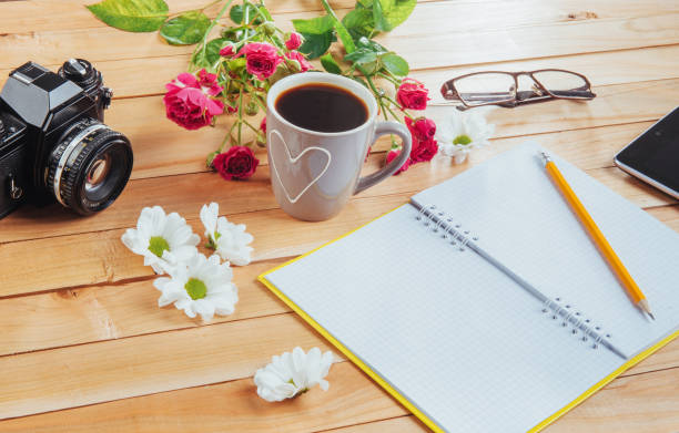 istock On wooden background notebook pencil, coffee and flowers. 843045608