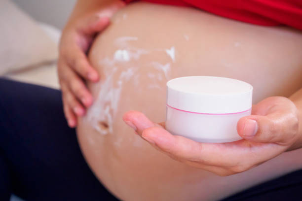 istock Pregnant Woman applying stretch marks cream on her belly 843052064