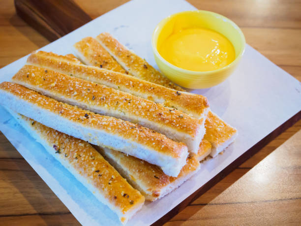 istock Bread sticks with sauce on wood table 843059658