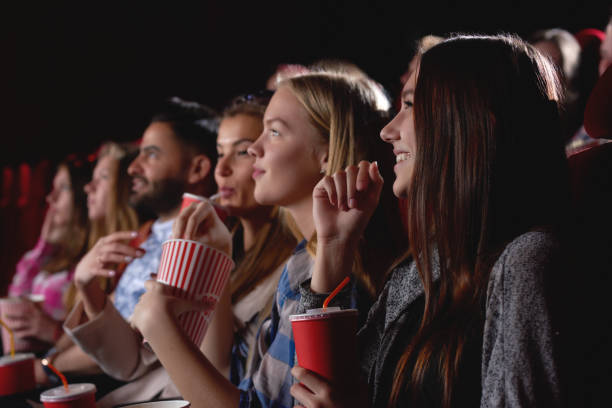 grupo de personas disfrutando de película en el cine - estreno fotografías e imágenes de stock