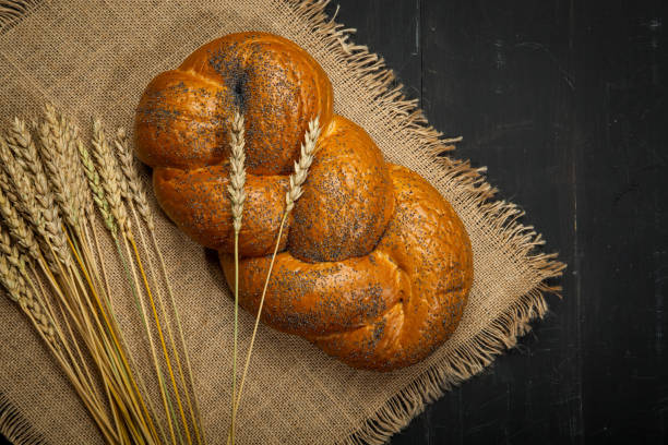 istock Wheat and bread on a black wooden background 843071624