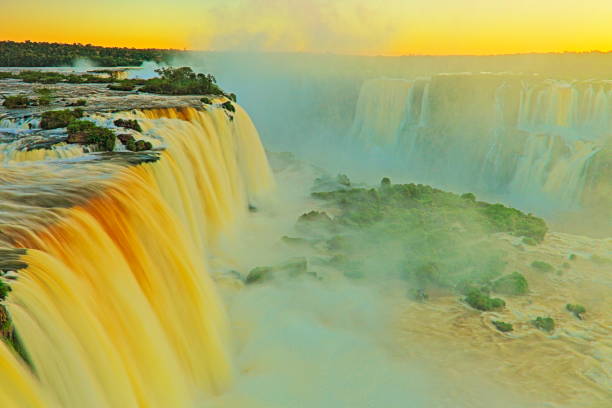istock Impressive Iguacu falls landscape, blurred motion from long exposure at dramatic sunset - Idyllic Devil's Throat - international border of Brazilian Foz do Iguacu, Parana, Argentina Puerto Iguazu, Misiones and Paraguay - South America 843071824