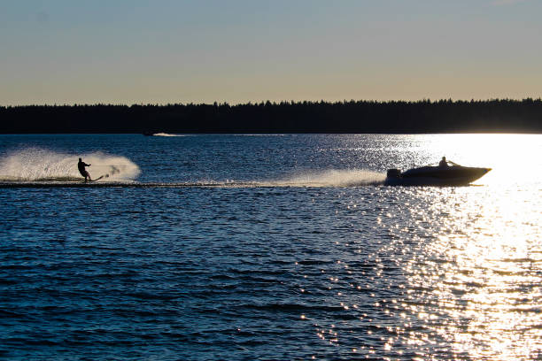 istock A boat and water skier silhouetted against a blue lake 843074886