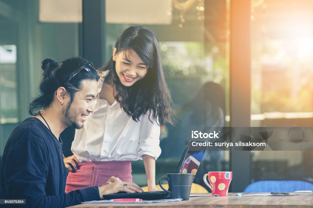 happiness emotion of asian younger man and woman ,freelance team working with computer laptop in home office Coffee - Drink Stock Photo