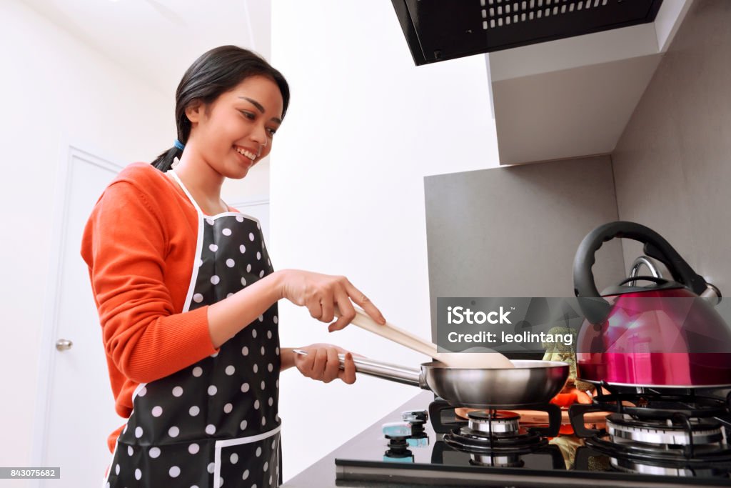 Mulher asiática usando a frigideira e cozinhar a sorrir - Foto de stock de Cozinhar royalty-free