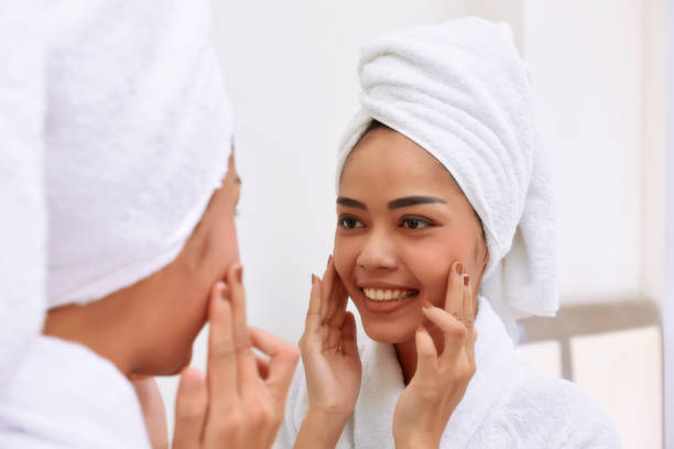 istock Young asian woman with bath towels cleanses her face 843075752