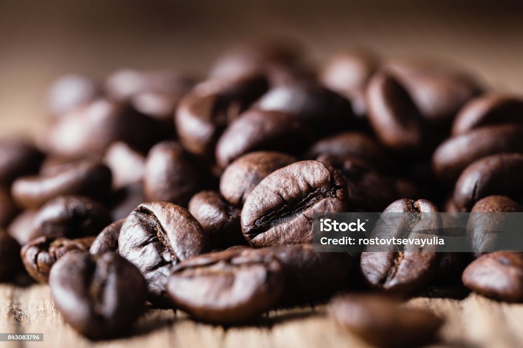 木製の背景にコーヒー豆の焙煎。 - コーヒー豆のロイヤリティフリーストックフォト