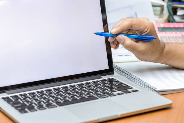 istock Businessman hands use pen pointing to laptop screen with copy space. 843086316