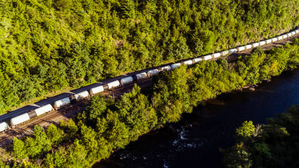 The cargo train on the railroad in Appalachian mountain along the Lehigh River, near by Jim Thorpe, Pennsylvania, USA. Aerial footage. The cargo train on the railroad in Appalachian mountain along the Lehigh River, near by Jim Thorpe, Pennsylvania, USA. 4K UHD aerail drone video. carbon county utah stock pictures, royalty-free photos & images