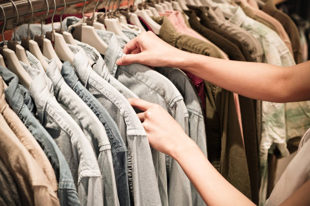 istock Hands choosing clothes on a rack in a showroom. 843091740