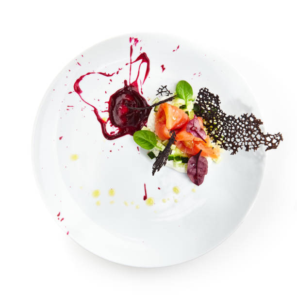 Specialties of the luxury restaurant Salmon with caviar, greens and cucumber on creamy sauce and basil leaves on white plate on an isolated background. Gastronomic restaurant menu. Top View garnish stock pictures, royalty-free photos & images