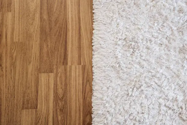 Photo of Close-up luxury white carpet on laminate wood floor in living room, interior decoration