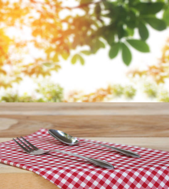 istock spoon with fork on checkered tablecloth and blur leaves background 843127496