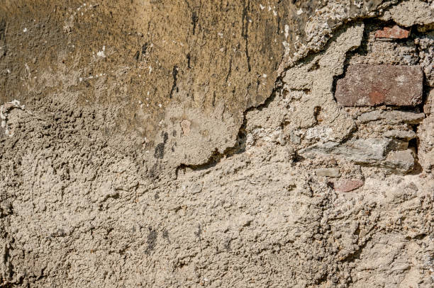 istock Background of natural cement plaster on the wall grey plain textured with cracks and brick in the upper right corner. 843134286