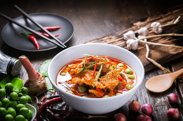 Red curry with pork and coconut milk. Red curry with pork and coconut milk, delicious Thai food on wooden table. thai food stock pictures, royalty-free photos & images