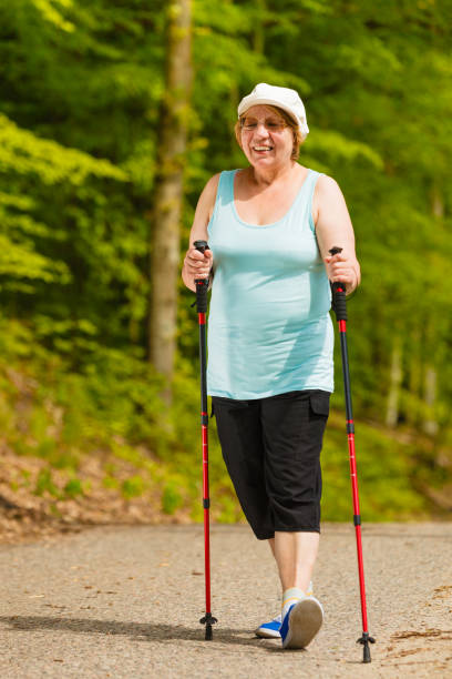 istock Senior woman practicing nordic walking in park 843141086