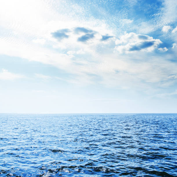 istock blue sea and low clouds with sun over it 843144172
