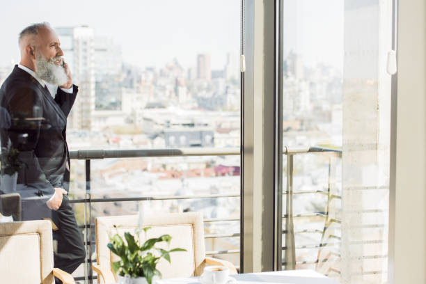istock businessman talking by phone on balcony 843147092
