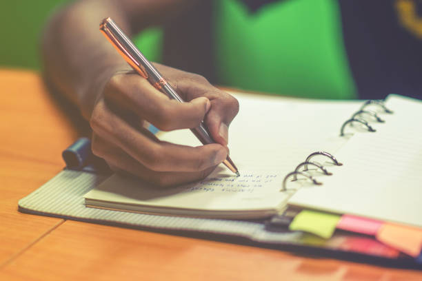 istock Man hand with pen writing on notebook. Young asian man writing form filling with register on paper notebook. Selective focus 843148466