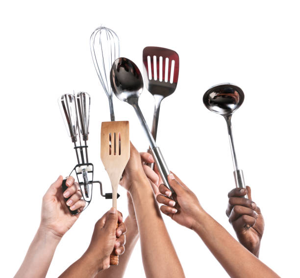 istock Six hands hold aloft a variety of kitchen utensils 843157568