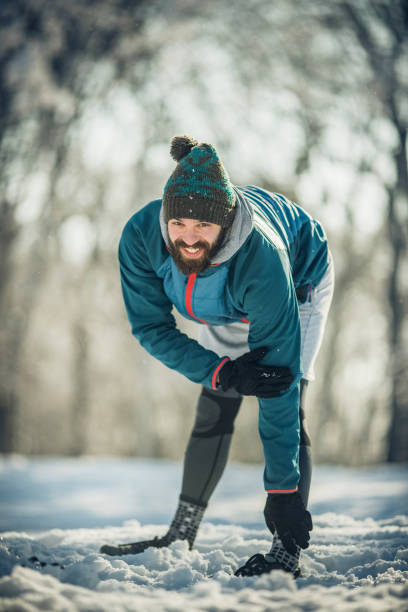 istock Happy athletic man warming up on the snow in the park. 843157708