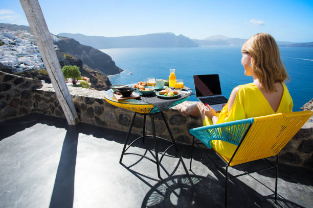 Woman working with laptop while on vacation in Mediterranean