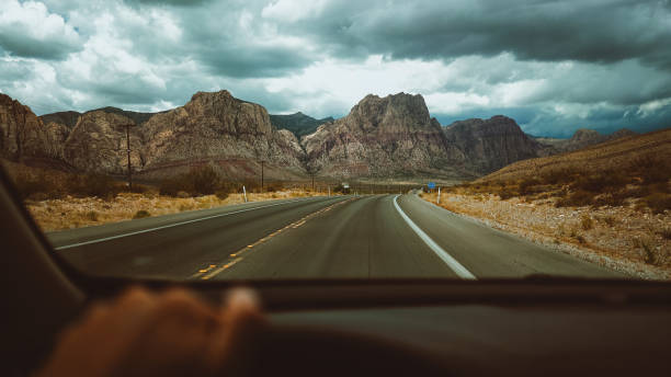 Driving a car on desert highway POV