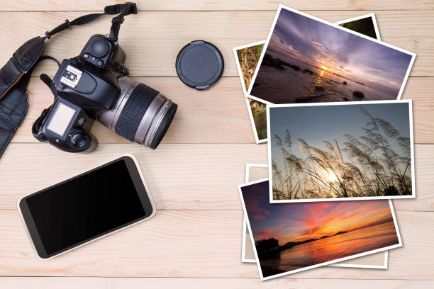 vieja cámara, smartphone y pila de fotos en fondo madera - cámara digital fotografías e imágenes de stock