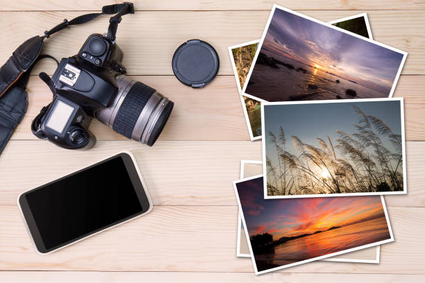 istock Old camera, smartphone and stack of photos on wooden background 843174388