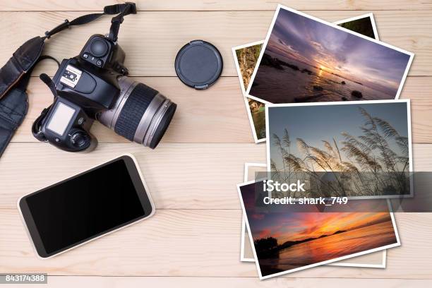 Old Camera Smartphone And Stack Of Photos On Wooden Background Stock Photo - Download Image Now