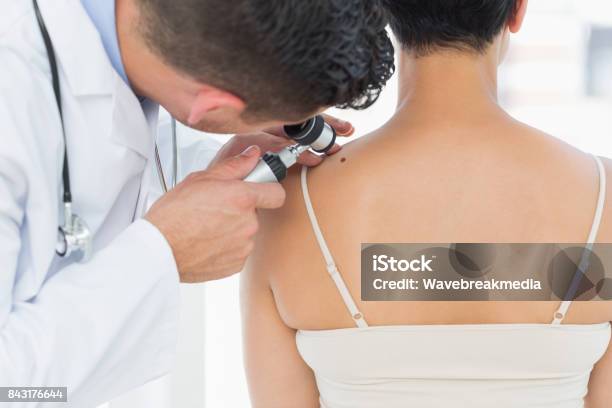 Dermatologist Examining Mole On Back Of Woman Stock Photo - Download Image Now - Medical Exam, Skin Cancer, Dermatologist