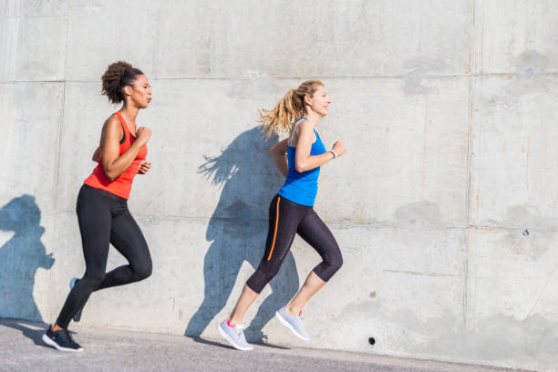 istock Two female athletes running together 843180176