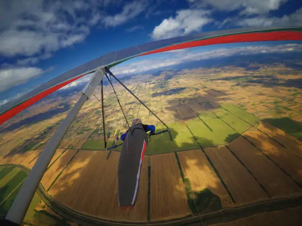 Onboard shot of hangglider pilot flying in the sky above beautiful Pelagonia valley