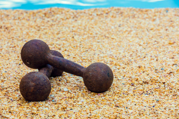 Retro iron grunge dumbbells on the beach