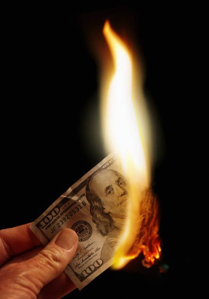 istock Hand holding burning American hundred dollar banknote 843182462