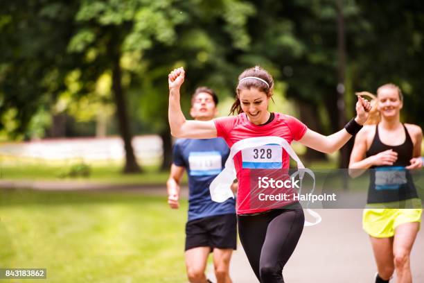 Junge Frau In Der Menge Die Über Die Ziellinie Laufen Stockfoto und mehr Bilder von Marathon