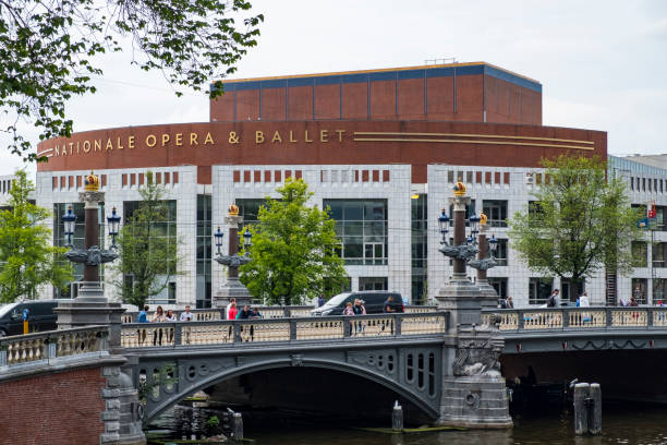 Stopera National Opera and Ballet in Amsterdam, The Netherlands Stopera National Opera and Ballet in Amsterdam, The Netherlands with the Blauwbrug bridge over the river Amstel in the foreground.  People are crossing the bridge. Amsterdam is the capital of The Netherlands and a popular travel destination for tourists. stopera stock pictures, royalty-free photos & images