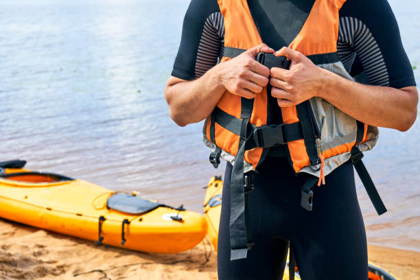 männliche wanderer neoprenanzug anziehen eine schwimmweste tragen - life jacket stock-fotos und bilder