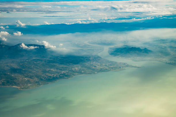 The city of Taipei, the capital of Taiwan, seen from an airplane during the afternoon. Some fog hanging over the city.