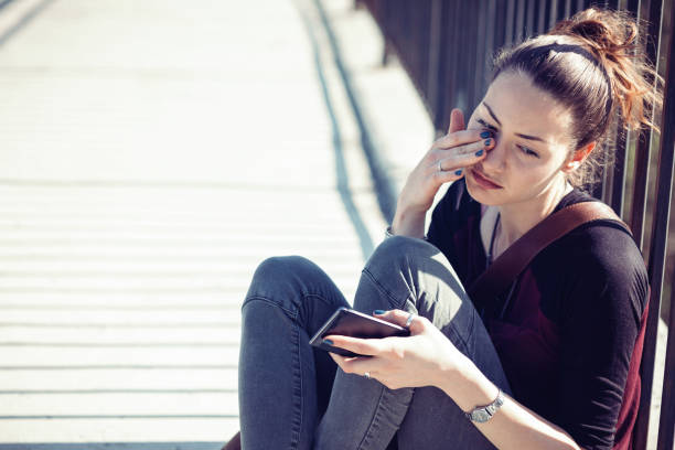 istock Young female holding her telephone and crying alone 843197426