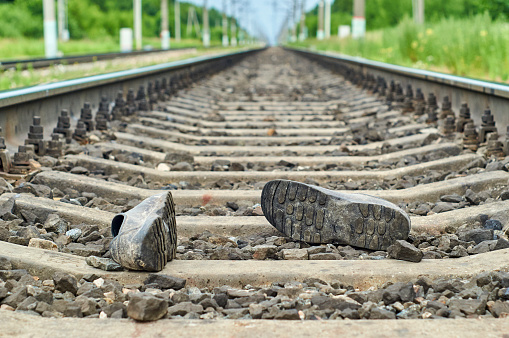 Accident on railway. Rubber boots lying on the railroad