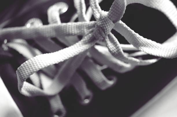 istock white shoelace tie on black sneakers shoe SELECTIVE FOCUS 843198720