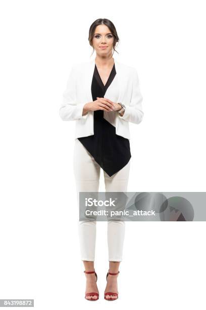 Friendly Smiling Business Female Presenter In Formal Suit With Hands Clasped Looking At Camera Stock Photo - Download Image Now