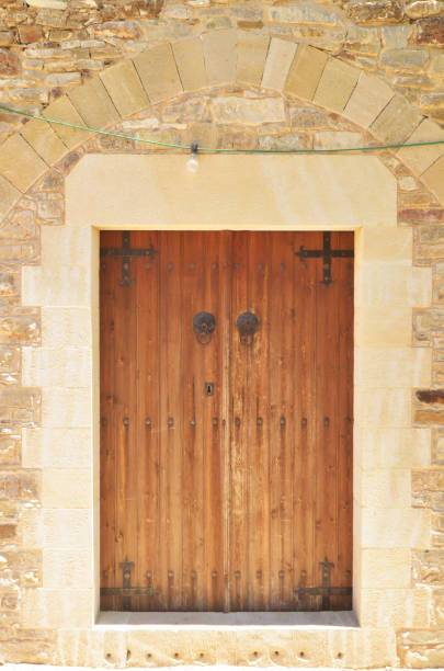 istock Rustic wood door under enclosed arch on sandstone building 843206210